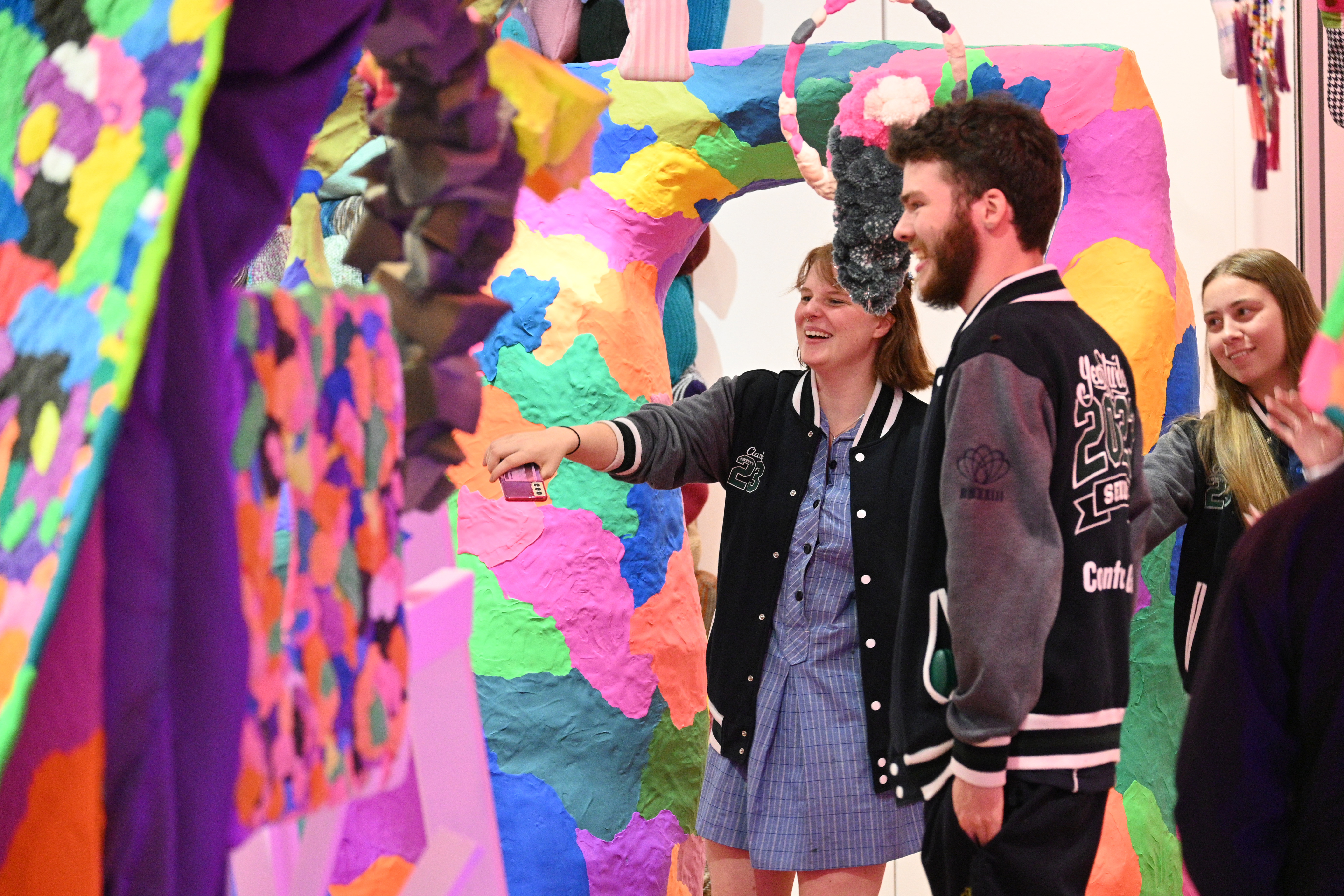 two year 12 students looking at a colourful craft installation