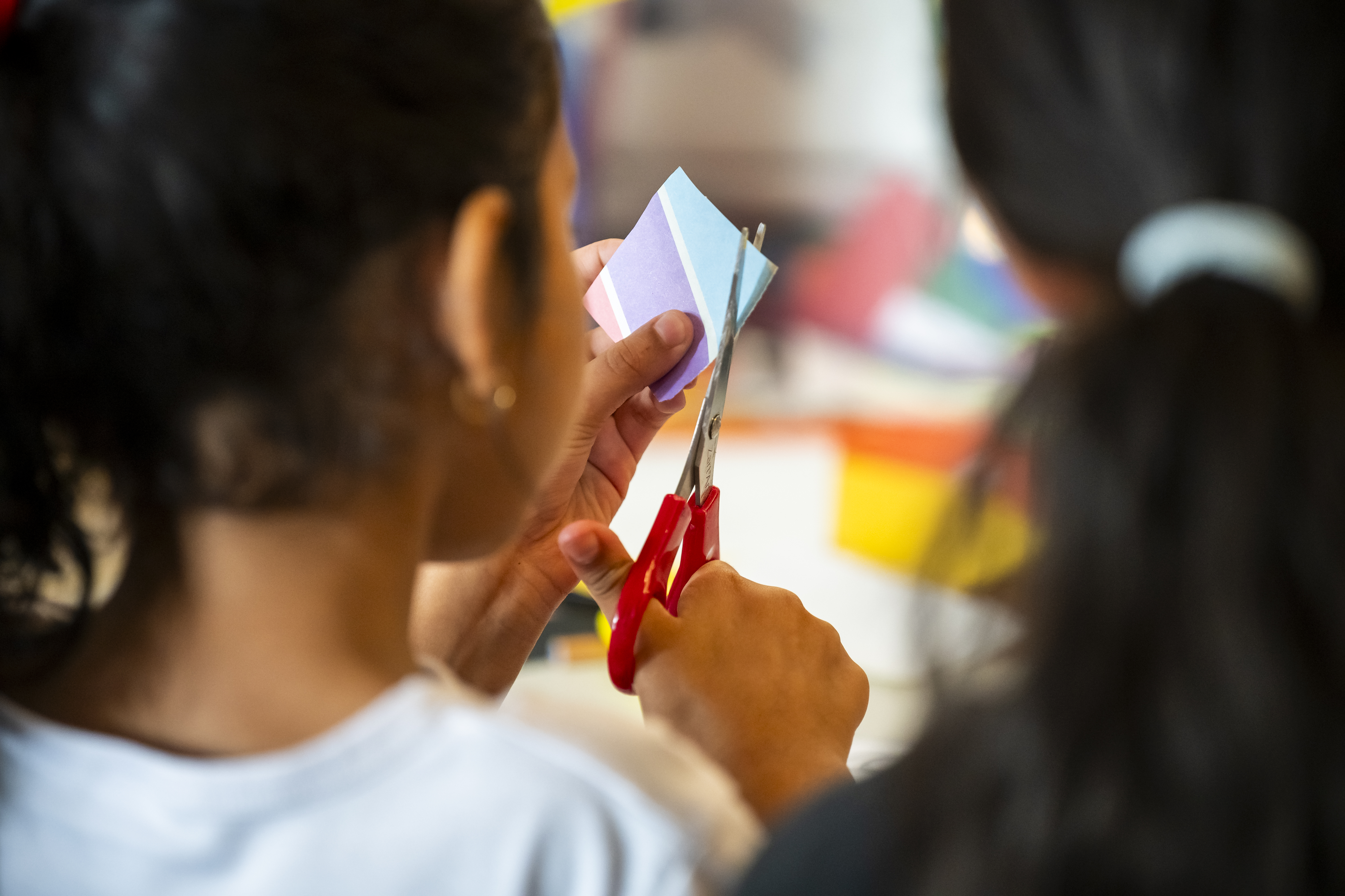 a child cutting paper using scissors