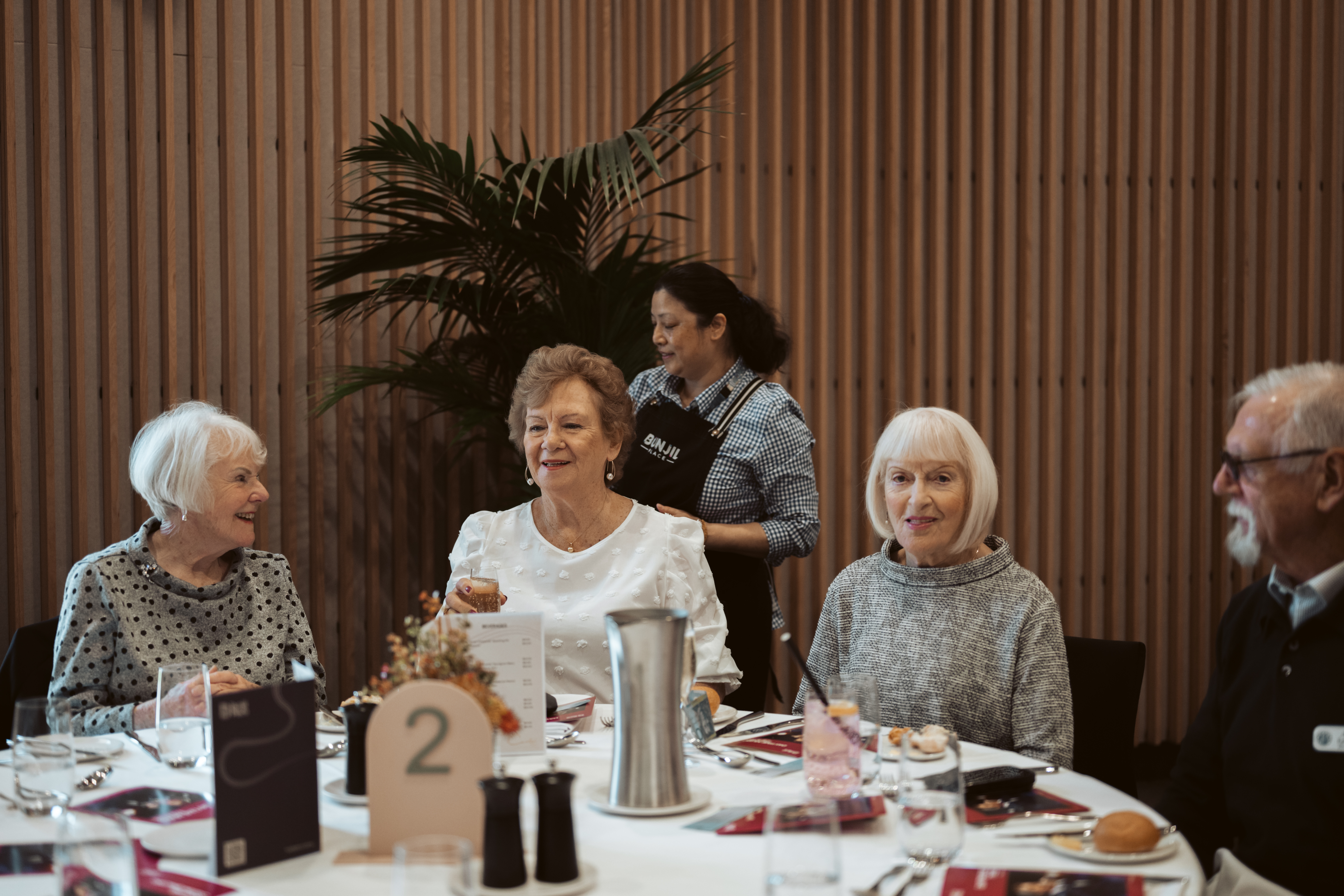 Three ladies and a man sitting down to lunch