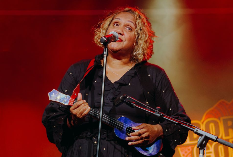 A woman plays a ukulele