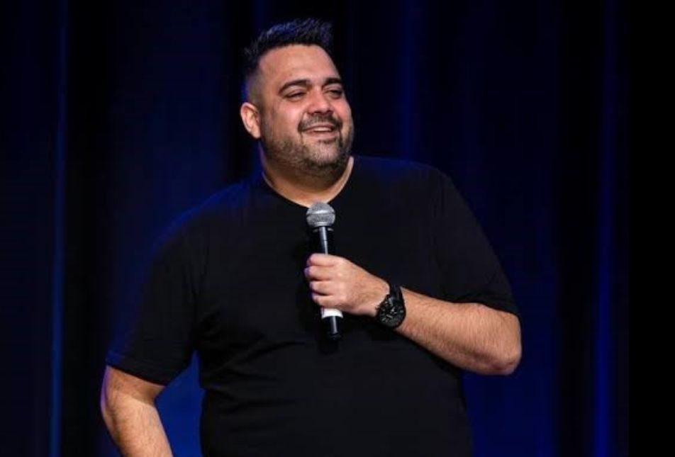 A man in a black shirt holds a microphone