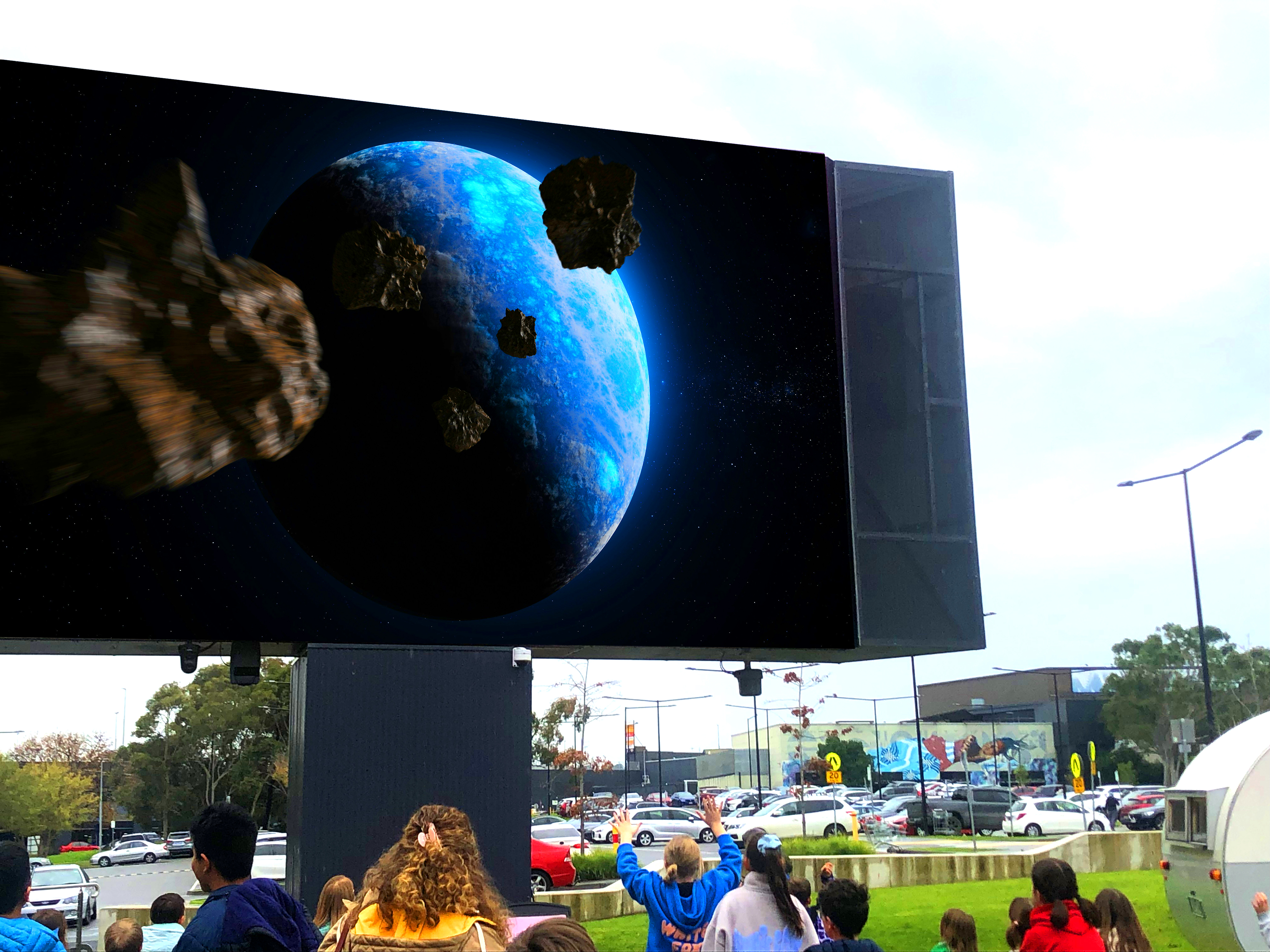 Children playing in front of an interactive game on the Bunjil Place outdoor screen