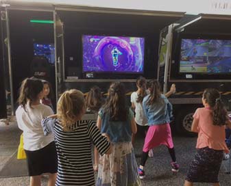 Children playing in front of a television screen.