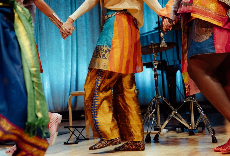 A close-up of clothing worn by people in a line holding hands