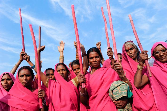 Several women in bright pink saris