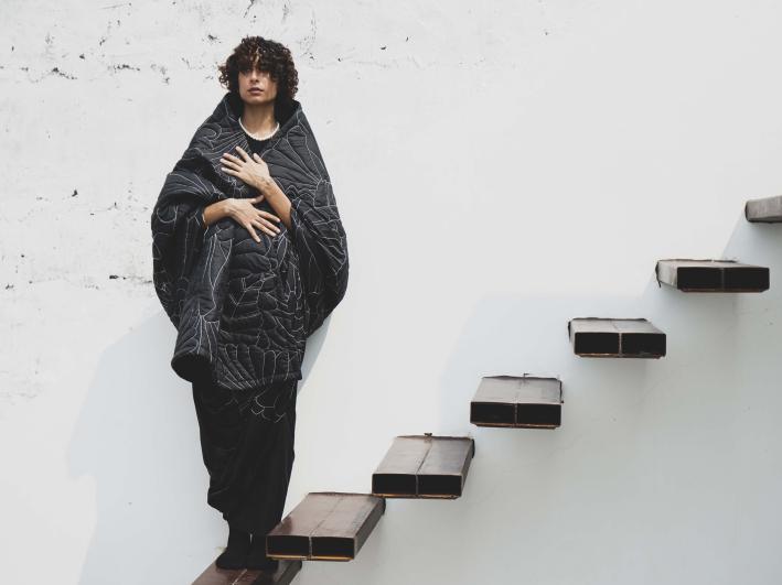 A woman standing on stairs modelling a quilted sari 