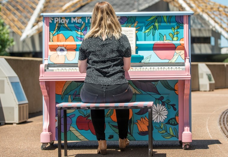 young woman playing public piano