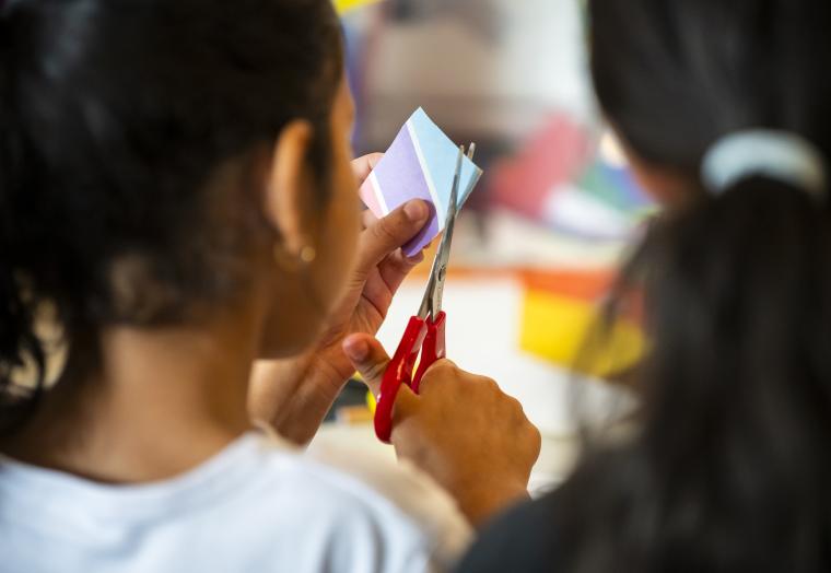 a child cutting paper using scissors