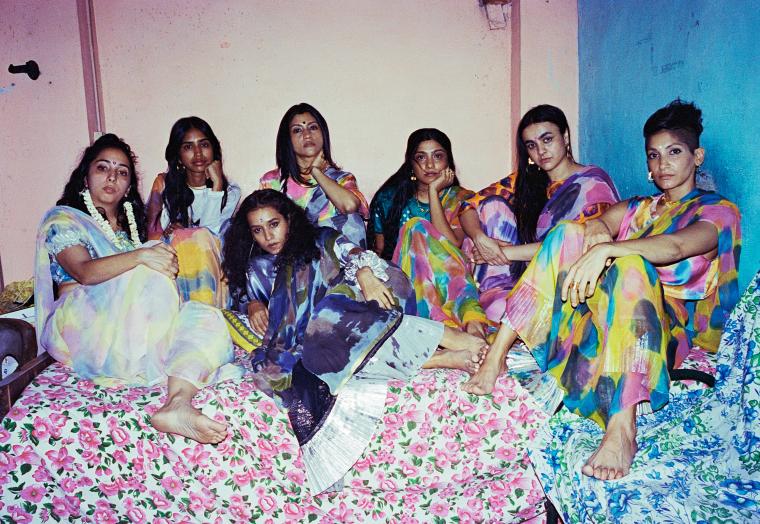A group of seven people sitting together, wearing saris designed by NorBlack NorWhiteite