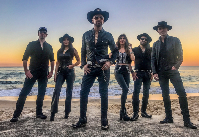 Six people in dark clothing stands against a bright sunset - members of Pseudo Echo