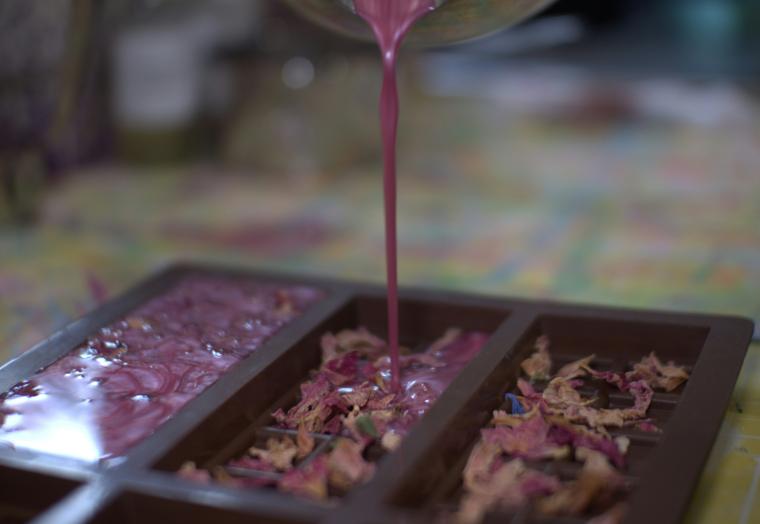 Pouring a pink liquid into rectangular casts