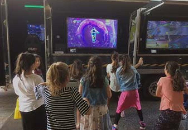 Children playing in front of a television screen.