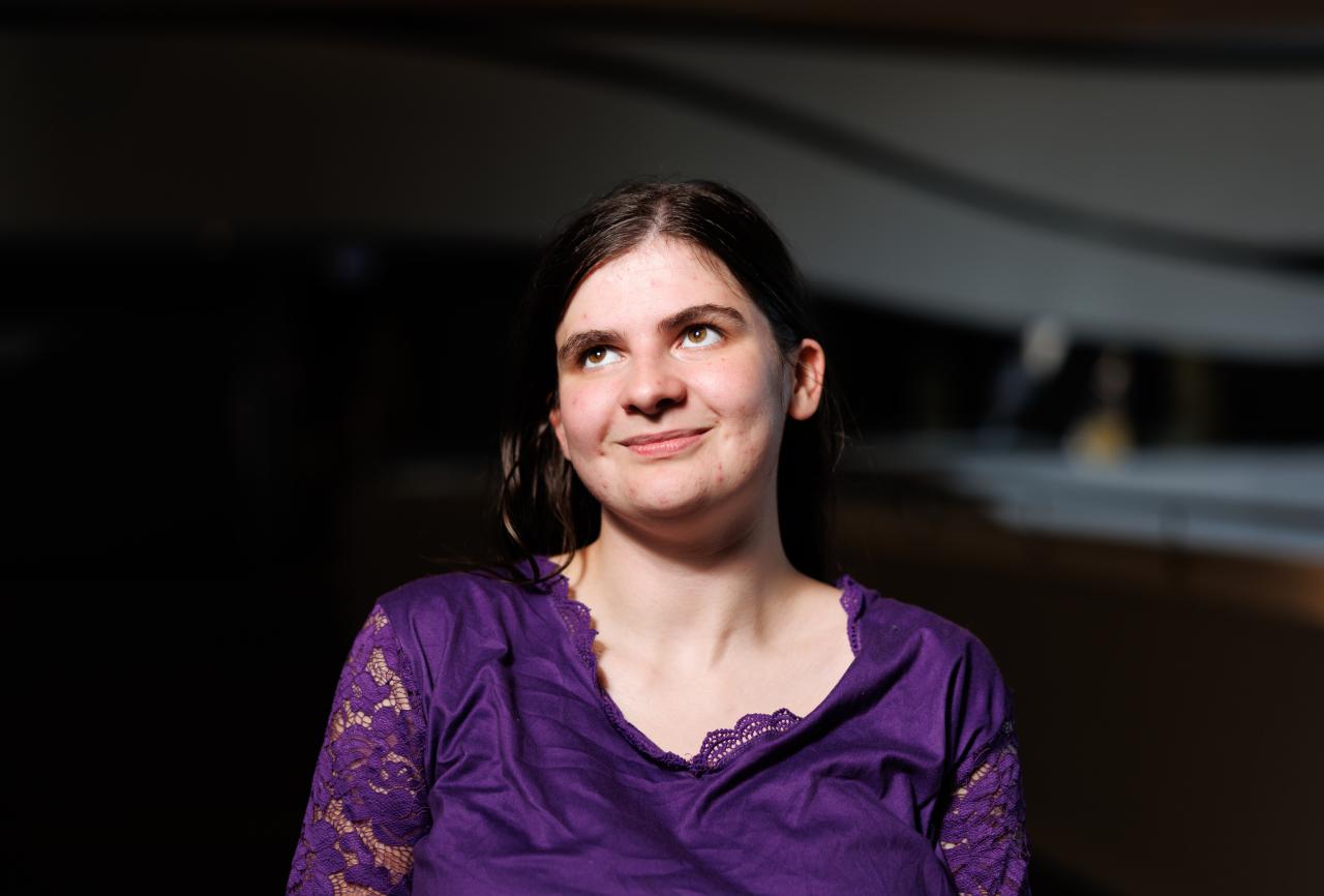 young woman wearing a purple top