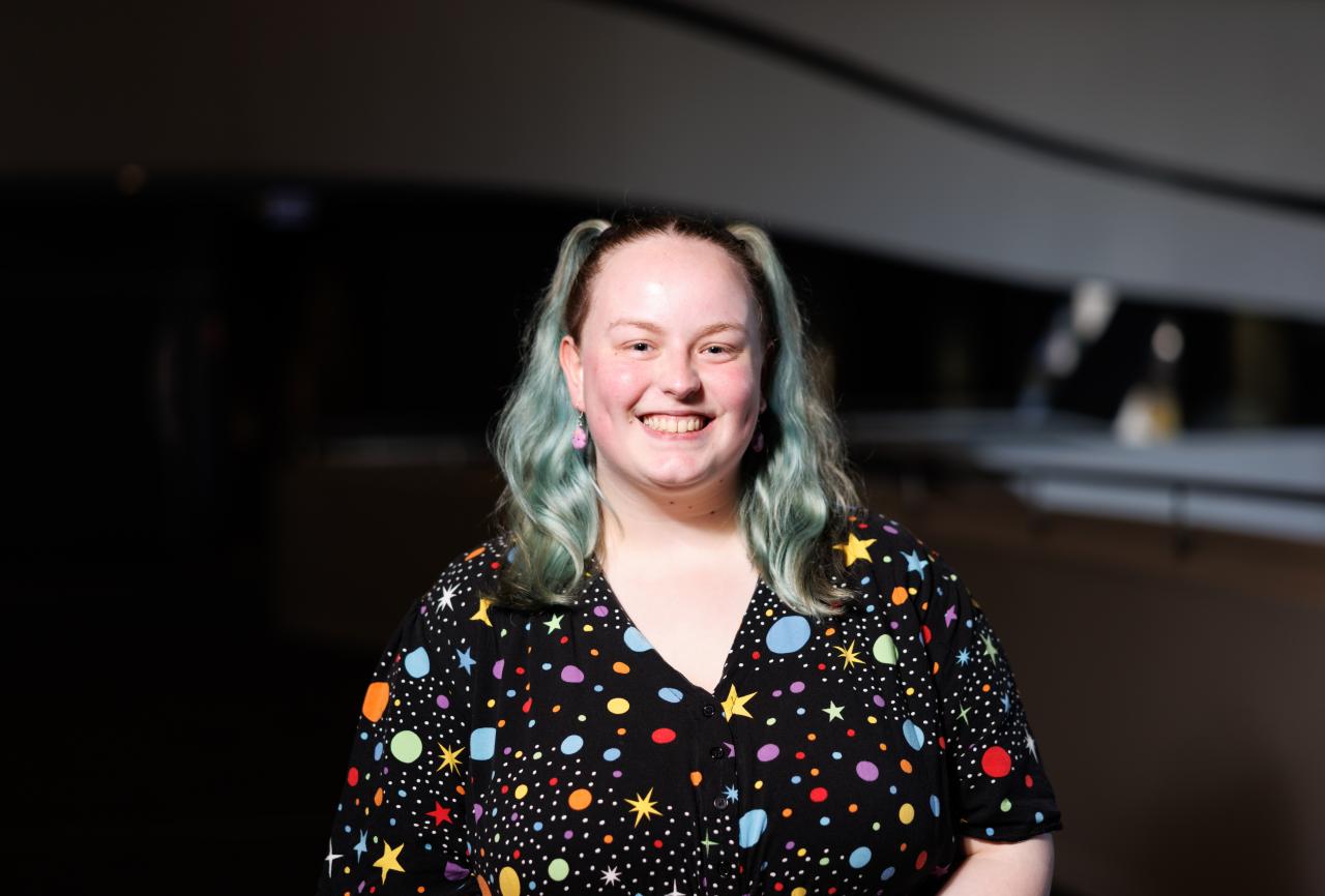 Young person wearing a black dress with coloured stars