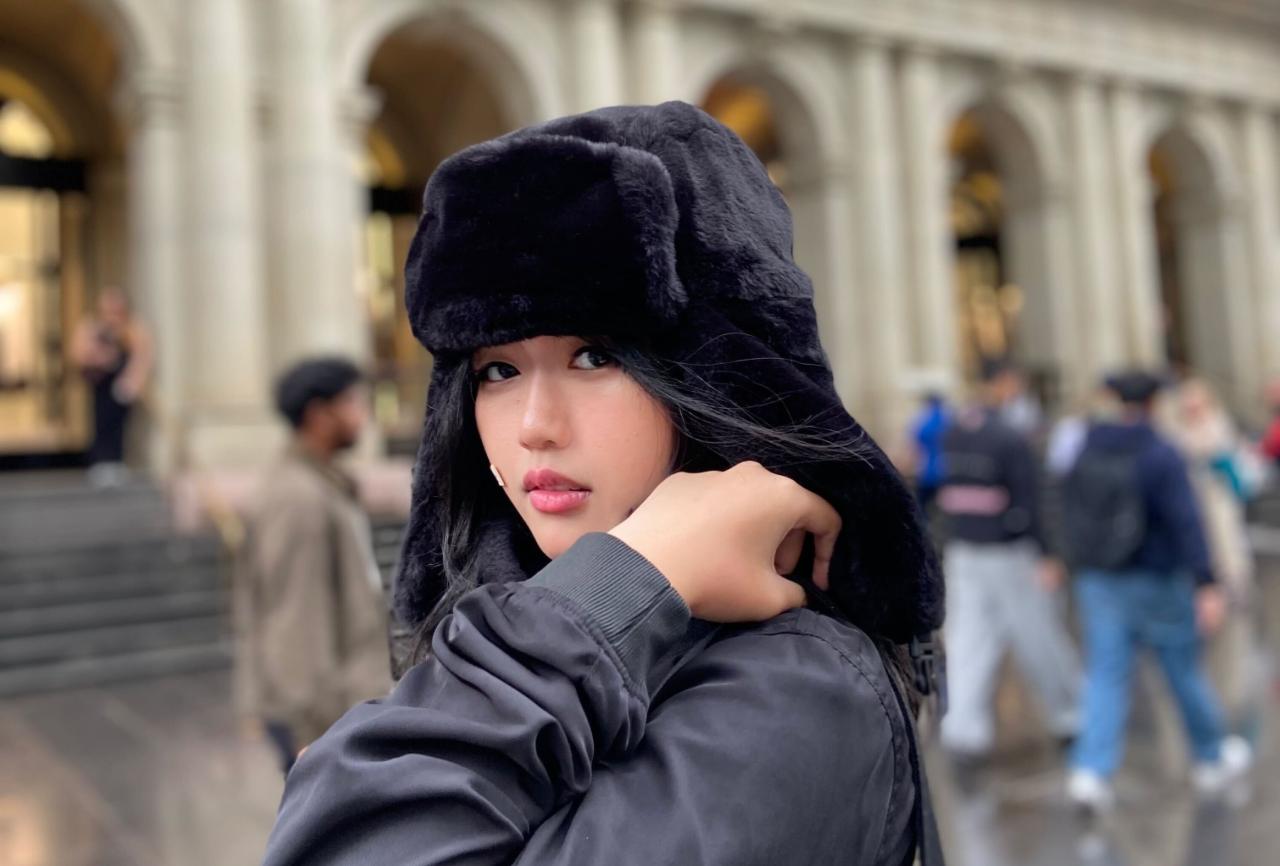 Young person wearing a black dress beanie and black jacket