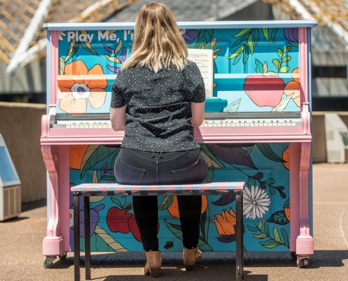 young woman playing public piano