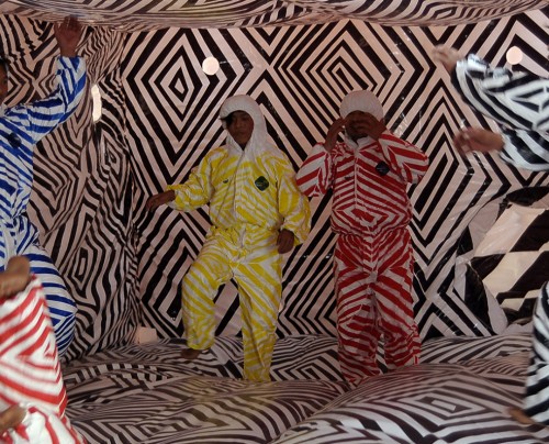 Adults jumping inside Brook Andrew's installation, The Cell.