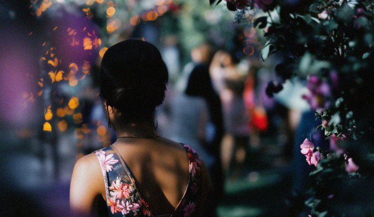 woman walking through a floral archway