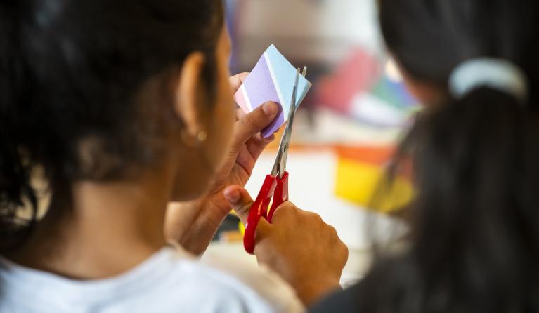 a child cutting paper using scissors