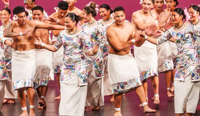 Young people dancing on stage in traditional costume 