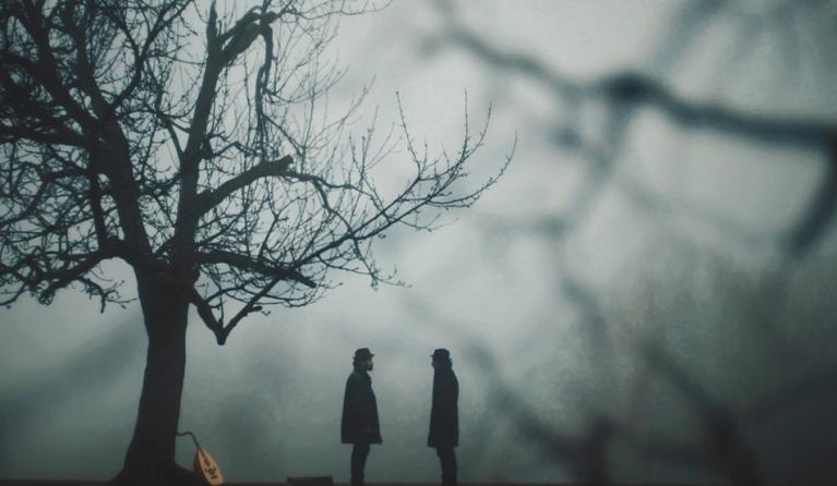 Silhouette of two figures facing each other in a spooky looking woods