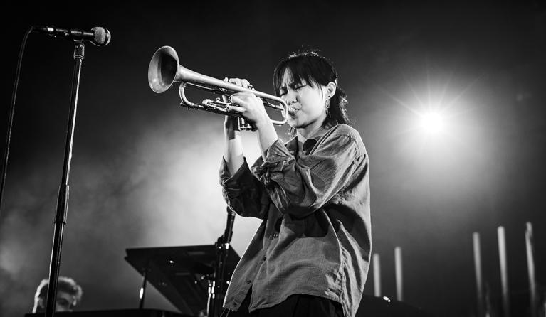 Musician Skylar Tang playing the trumpet - image is in black and white