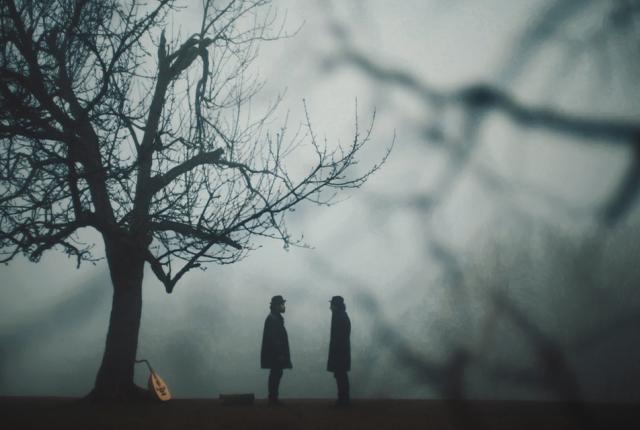 Silhouette of two figures facing each other in a spooky looking woods
