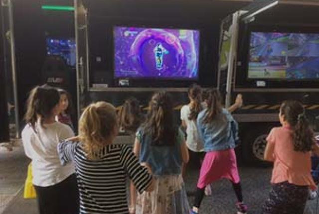 Children playing in front of a television screen.