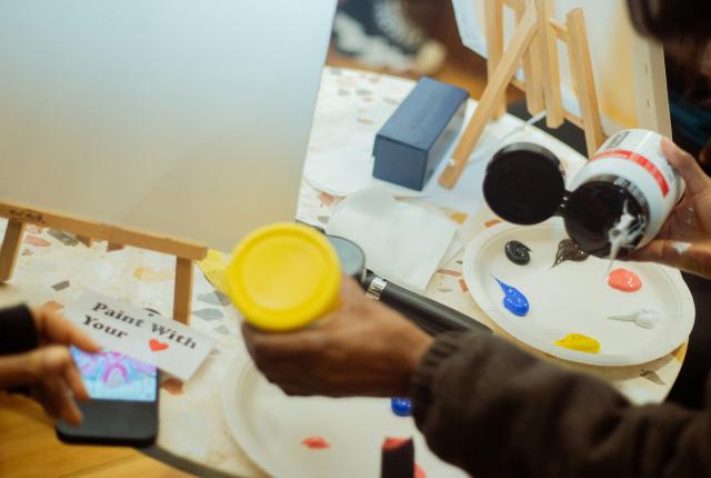 person putting paint onto plate