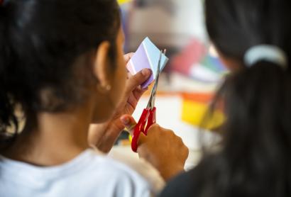 a child cutting paper using scissors