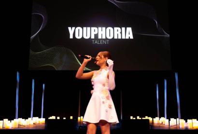 A girl in a white dress sings into a microphone - Advanced Singing Competition