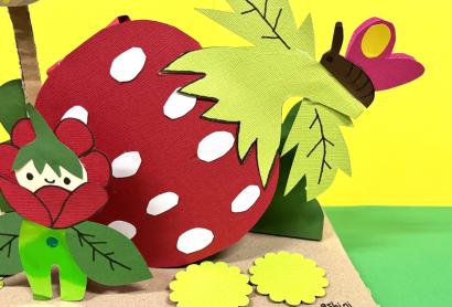 a paper strawberry with a butterfly sitting on top