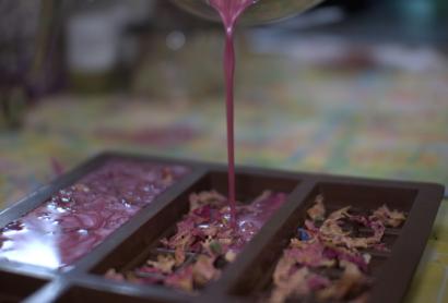 Pouring a pink liquid into rectangular casts