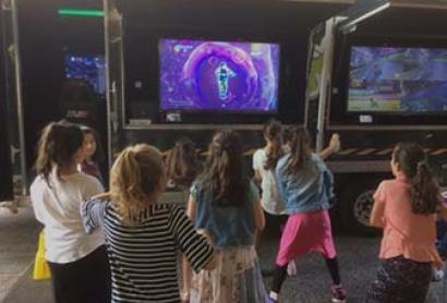 Children playing in front of a television screen.